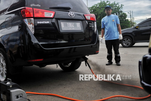 Petugas melakukan uji emisi kendaraan bermotor secara gratis di Jalan Perintis Kemerdekaan, Pulogadung, Jakarta, Selasa (3/12/2024). Dinas Lingkungan Hidup DKI Jakarta bekerja sama dengan Dinas Perhubungan dan Kepolisian menyelenggarakan kegiatan Pemantauan Kepatuhan Kewajiban Uji Emisi bagi pengendara untuk mensosialisasikaan tentang pentingnya menjaga kualitas udara dengan menggunakan kendaraan sesuai standar baku mutu emisi. Bagi pengendara yang tidak lolos uji emisi akan dikenai denda tilang berbasis ETLE, denda pajak tahunan serta tarif parkir tertinggi di beberapa lokasi tertentu.