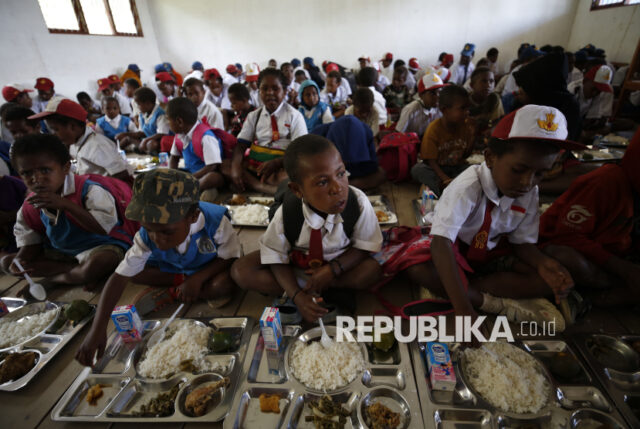 Pelajar menerima paket makanan Makan Bergizi Gratis di SD Santo Michael Bilogae, Distrik Sugapa, Kabupaten Sugapa, Intan Jaya, Papua Tengah, Senin (20/1/2025). Kementerian Pertahanan melalui Kogabwilhan III mendistribusikan paket makan bergizi gratis sebanyak 1000 paket makan diperuntukkan bagi sekolah-sekolah di salah satu daerah rawan konflik di Disktri Sugapa menggunakan helikopter serta diolah di dapur yang dikelola TNI. Program Makan Bergizi Gratis disebut sebagai langkah besar dalam sejarah kebijakan sosial Indonesia untuk mengatasi masalah malanutrisi, stunting, serta mendorong penguatan ekonomi lokal.   