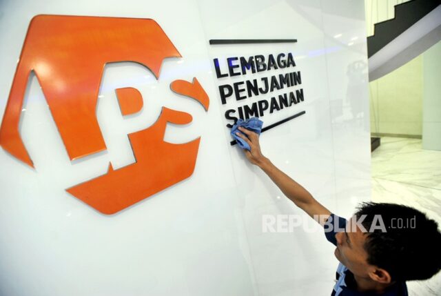 Karyawan membersihkan logo Lembaga Penjamin Simpanan (LPS) di Jakarta.