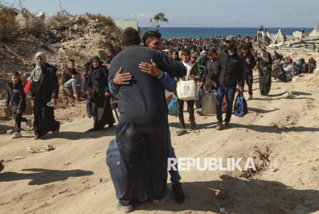 Warga Palestina berpelukan saat berjalan kaki pulang kembali menuju rumah mereka di Jalur Gaza Utara, Senin (27/1/2025). Ribuan warga Palestina untuk pertama kalinya kembali ke rumah mereka di wilayah Gaza Utara yang sebelumnya ditutup oleh Israel.